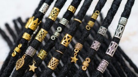 dreadlocks decorados com contas, anéis e manguitos dourados e prateados